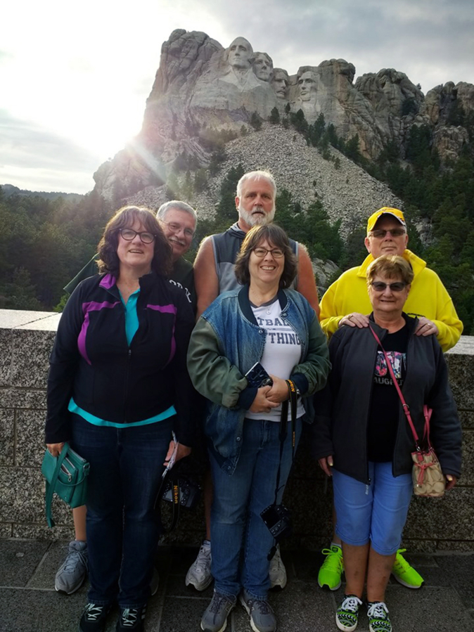 Doug Norcross, Rick Foster and Arnie Hoag (back row left to right), and Julie Norcross, Bobbi Foster and Linda Wade pose for a photo at Mount Rushmore National Memorial in Keystone, South Dakota.