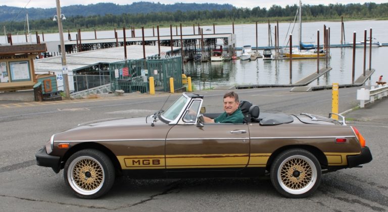 Washougal resident Larry Keister sits in the driver&#039;s seat of his 1978 MGB sports car, which will be entered into the Port of Camas-Washougal&#039;s Wheels and Wings event, to be held Aug. 24 at Grove Field.