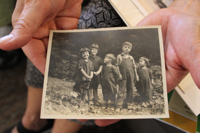 Rosemary Knapp holds a photo from the 1920s of Cay Knapp Smith (far left), her brothers, Hugh (third from left) and Donald (second from right) and their cousins.