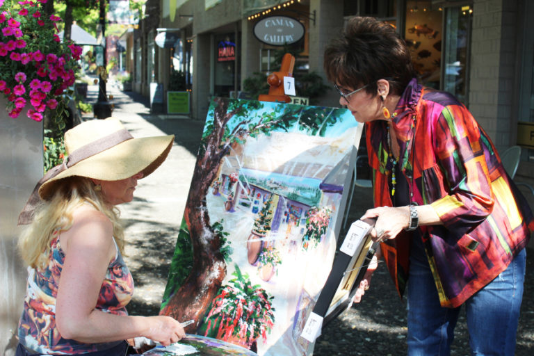 Artist Jane DeForest (left) talks to Camas Gallery owner Marquita Call during the 2018 Plein Air event. At top: Artist Sarah Bang paints in downtown Camas, near Arktana shoe store, during the 2018 Plein Air event.