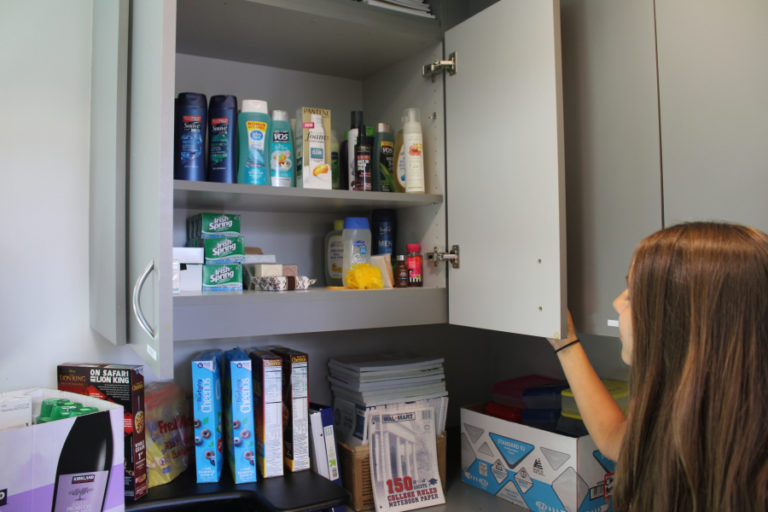 Olivia Eagle, with the Camas School District, shows a cabinet filled with toiletries and other home supplies at the district&#039;s Family-Community Resource Center.