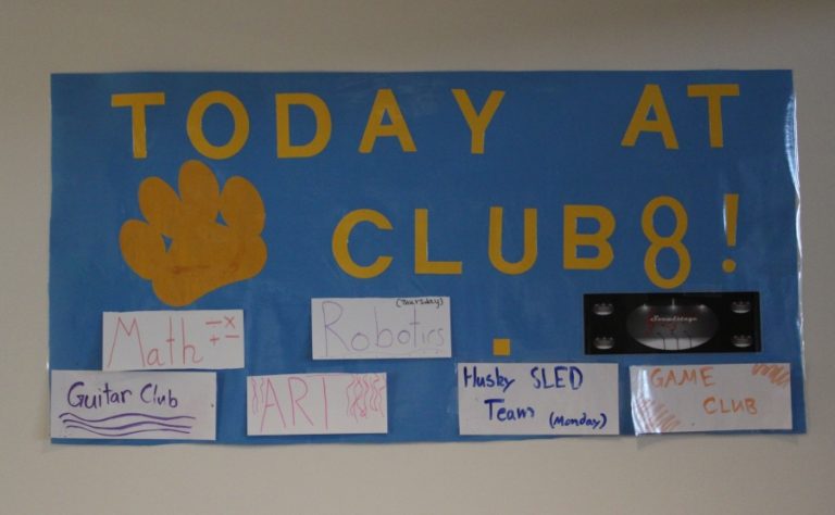 A sign hanging on a wall at Jemtegaard Middle School lists activities for the Club 8 program.