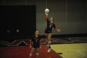 Camas High School volleyball player Makayla Buzzell (right) serves (right) with teammate Emma Villaluz in the backcourt during the Papermakers' match against Columbia River High School on Sept. 10. (Wayne Havrelly/Post-Record)
