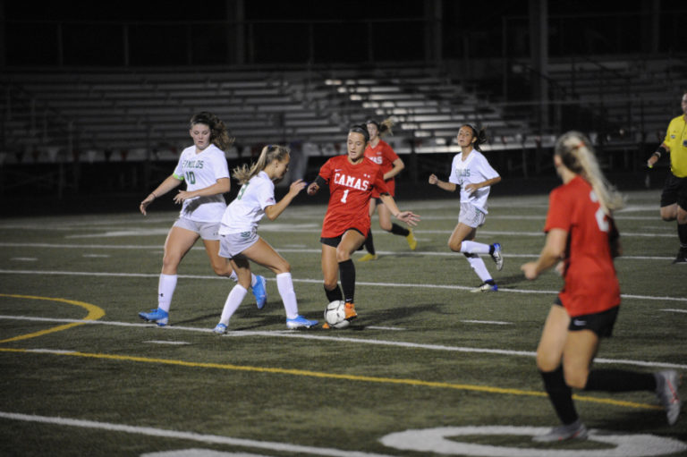 Camas High School soccer player Avery Smith dribbles through Reynolds (Ore.) High School defenders during the Papermakers&#039; home opener on Sept. 12.