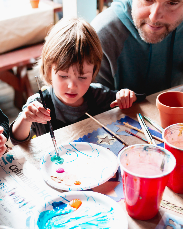 A child experiments with paint colors at a TreeSong class.