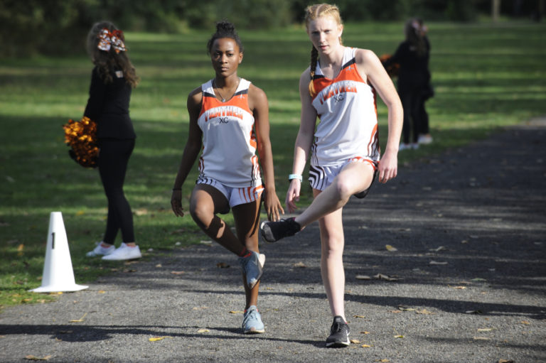 Washougal High School runners Clara Best (left) and Savea Mansfield (right) warm up before their first home race of the season Sept. 18.