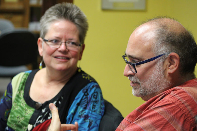 Paul Iarrobino (right), the founder of Our Bold Voices, talks to group member Heidi Bruins Green at a Sept. 27 rehearsal.
