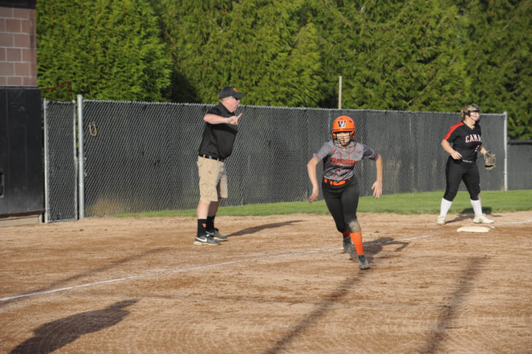 Washougal High School slowpitch softball coach John Carver sends a baserunner home during the Panthers&#039; Sept. 25 game at Camas High School.