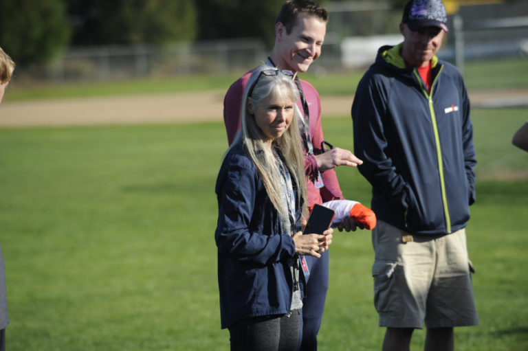 Camas High School cross country coach Laurie Porter (left) and assistant coaches Andrew Kaler (center) and Matt LaGrande talk strategy as the Papermakers&#039; boys and girls teams prepare for postseason action.
