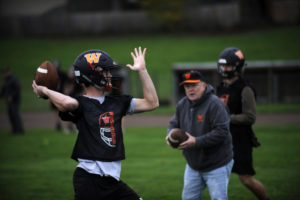 Washougal High School senior quarterback Dalton Payne (left) works on technique with assistant coach Bill Gladden (center) in preparation for the Panthers' Oct. 25 showdown against Hockinson High School. (Wayne Havrelly/Post-Record)