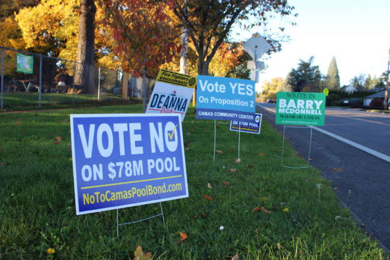 Kelly Moyer/Post-Record 
 Campaign signs against (front) and for (rear, center) the city of Camas&#039; Proposition 2, which would allow city leaders to take out up to $78 million in bonds to build a new community-aquatics center and renovate three sports fields, stand near other campaign signs outside Crown Park in Camas. (Illustration courtesy of city of Camas)