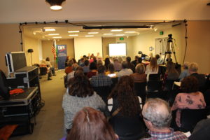 A crowd of people listen to Gary Medvigy and Adrian Cortes, candidates for a Clark County Council position, speak at the Clark County League of Women Voters candidate forum on Oct. 23 at Camas Public Library.