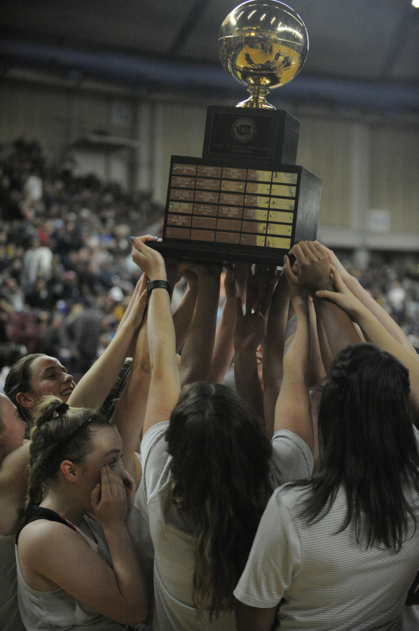 Members of the Washougal girls basketball team hold the 2A state championship trophy after beating West Valley (Spokane) in the Hardwood Classic championship game in Yakima, Wash., on Feb. 28, 2019.