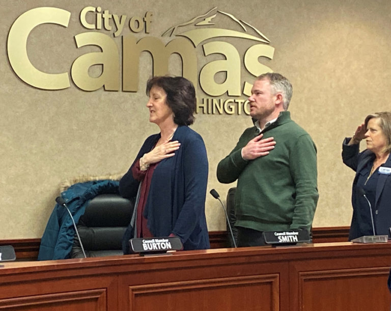 Newly elected Camas Mayor Barry McDonnell (center) and newly elected Camas City Councilwoman Shannon Roberts (right), a United States Navy veteran, join Camas City Councilwoman Melissa Smith (left) and other council members during the Pledge of Allegiance at the start of the city council&#039;s Dec.