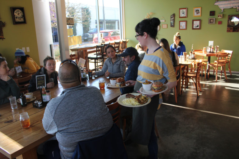OurBar manager Sara Wakeman serves meals to a group of people at the Washougal restaurant on Friday, Nov. 22.
