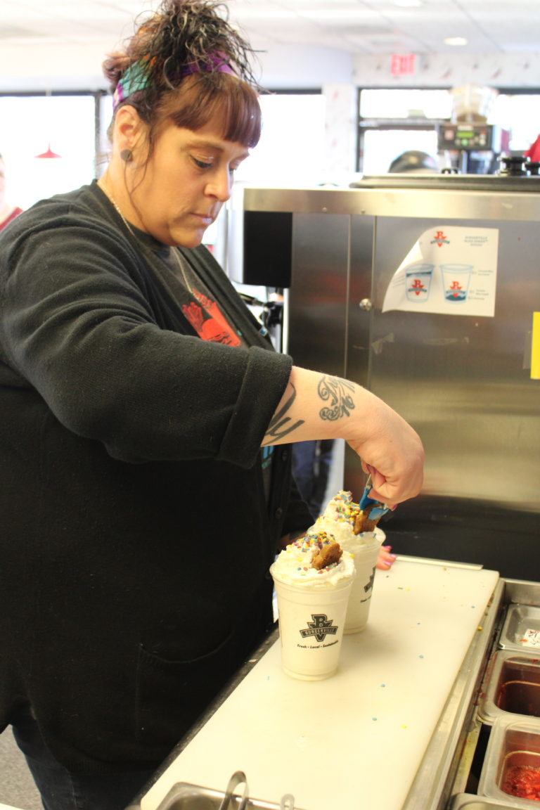 Shannon Lindberg, a team manager at the Vancouver Heights Burgerville, places a “gingerbread baby” on top of the company’s seasonal Gingerbread Shake, on Thursday, Dec. 5, at the Camas Burgerville on Northeast Third Avenue.