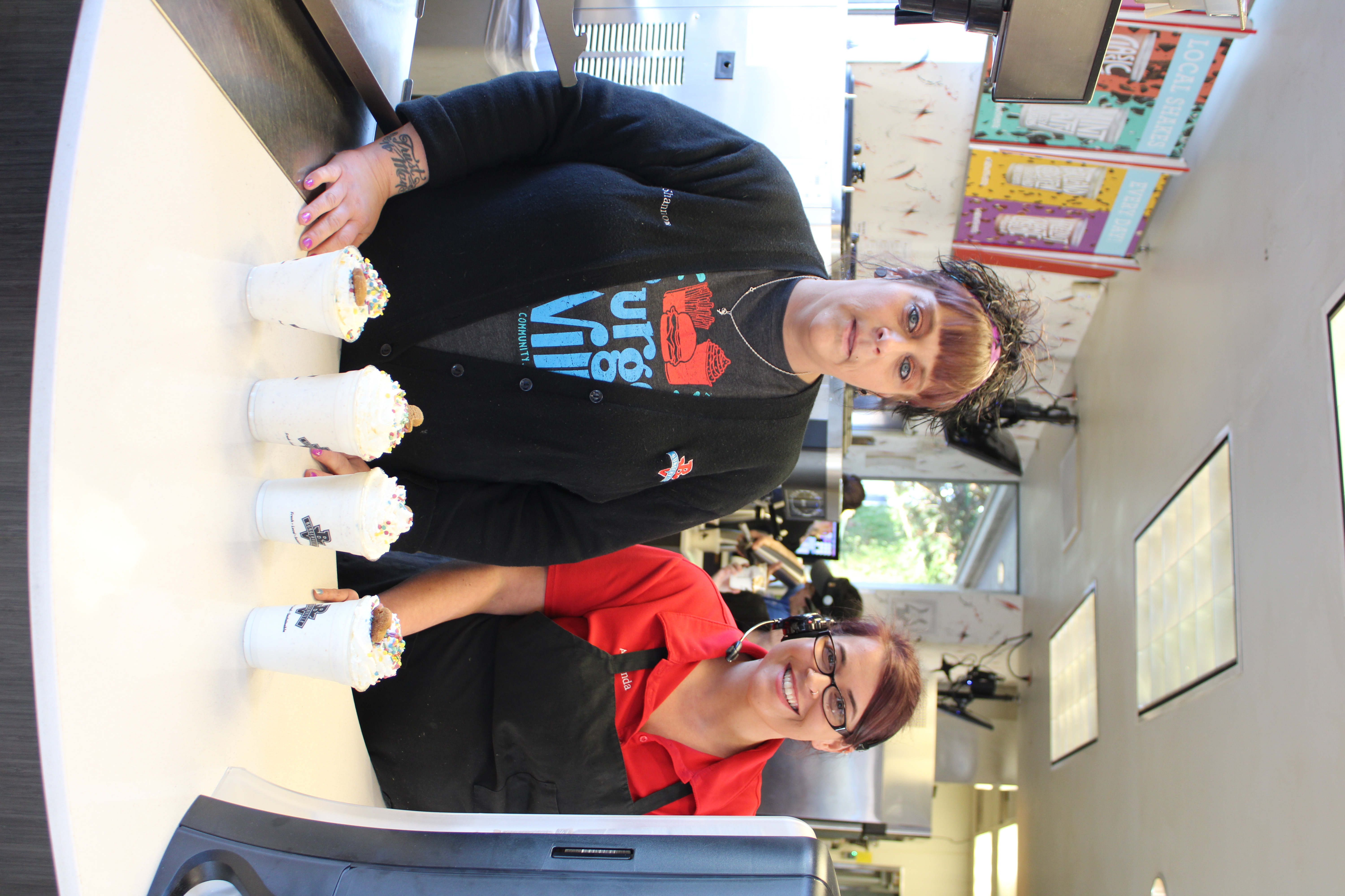 Shannon Lindberg (left), a team manager at the Vancouver Heights Burgerville, and Amanda McIntyre (right), a team manager at the Camas Burgerville, serve four of the restaurant’s seasonal gingerbread shakes, which use ingredients from a Camas couple’s cookie company, on Thursday, Dec. 5, at the Camas location.