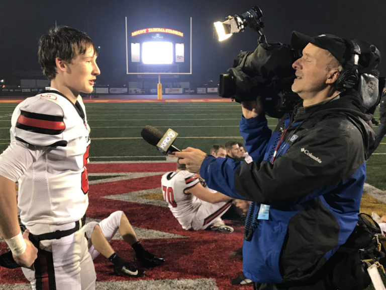 Camas High School senior quarterback Blake Asciutto is interviewed after the 4A state championship game by photographer Bill Skok from KIRO-TV in Seattle.