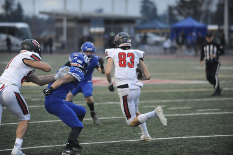 Camas High School senior reciever Jackson Clemmer puts a move on defenders after catching a pass during the 4A state championship game in Tacoma on Dec. 7.