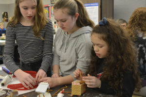 Jemtegaard Middle School sixth-graders Paige Prynn (left), Samantha Gifford (center) and Taylor Cotton (right) work on a candy cane "crime scene" for their school's candy display competition. (Photo courtesy of WSD)