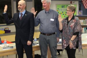 Jim Cooper (center) is sworn in to his Washougal School District No. 1 director position at a Dec. 9 meeting at Gause Elementary School. Later in the meeting, the board members voted for Cory Chase (left) to retain his board president position, and voted Angela Hancock (right) as board vice president.
