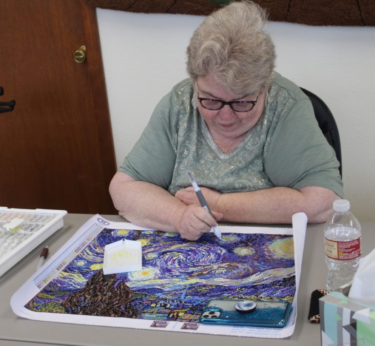 Doug Flanagan/Post-Record 
 Washougal resident Jill Fortman puts the finishing touches on her Diamond Dotz project at A Palce to Create in Washougal. (Doug Flanagan/Post-Record)