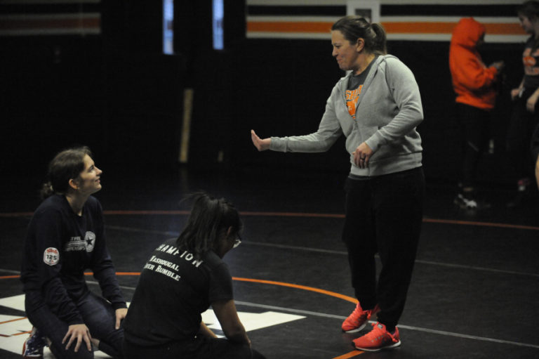 Washougal High School (WHS) girls wrestling coach Heather Carver (right) goes over some moves in the WHS wrestling room.