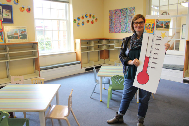 Camas Library Director Connie Urquhart holds a fundraising barometer inside the library's storytime room Jan. 17, 2019.