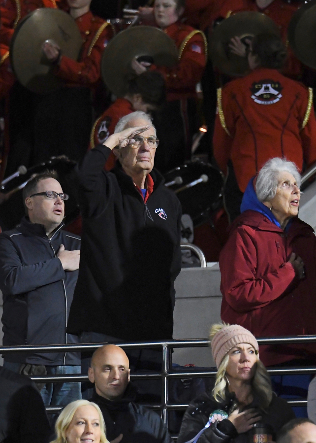 This photo of Jake Blair&#039;s grandfather saluting an American flag at a Camas football game is an example of how Cavin&#039;s photography transcends sports.