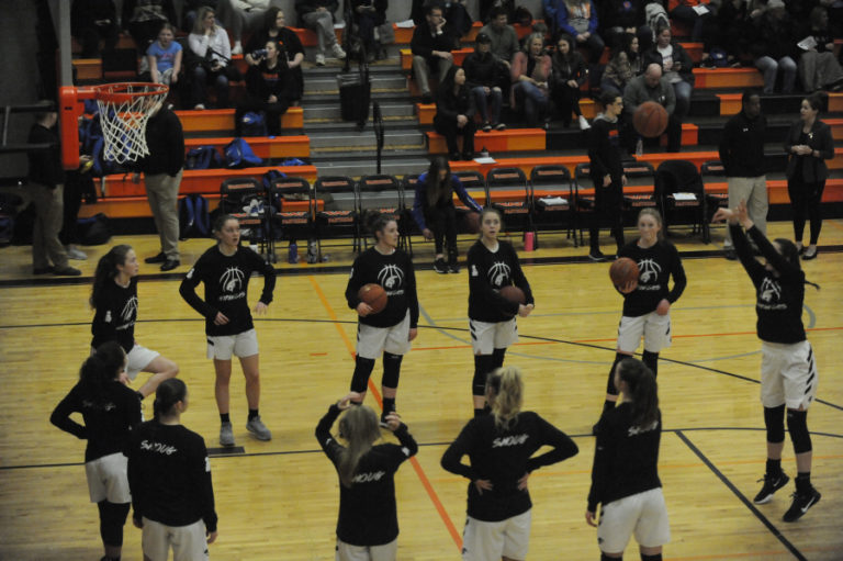 Washougal girls basketball players warm up for a game against Ridgefield on Jan. 27, wearing their &quot;Shoug&quot; warmup uniforms.