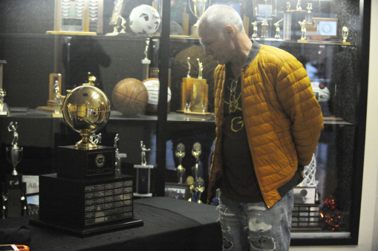Washougal High School alum Jeff Kinart looks at the the 2A girls basketball state championship trophy which sits in the hallway during every Panthers home game this season.