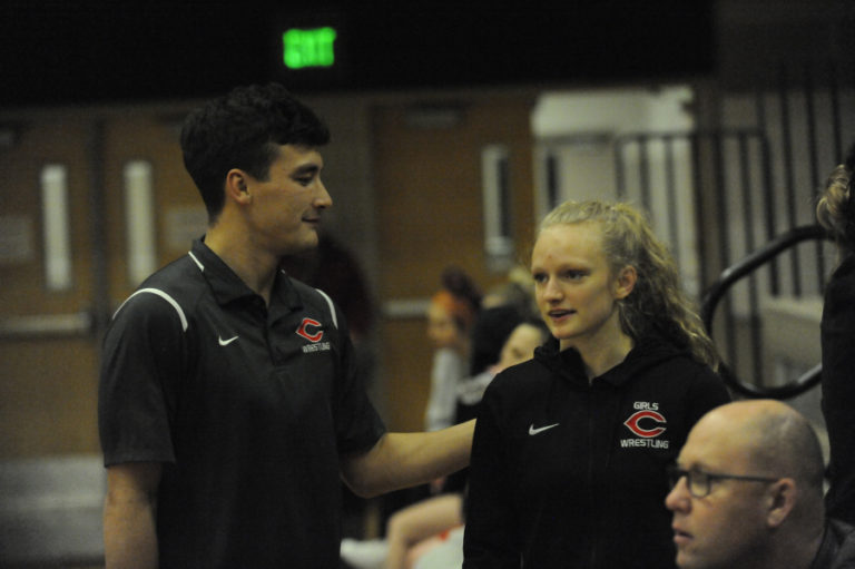 Camas wrestler Ava Weathrl (left) is congratulated after her win by assistant coach Kenji Yamashita on Jan.