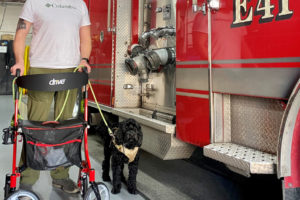 Camas-Washougal Fire Department Training Captain Chris Richardson stands near the fire department's newest engine with his service dog, Sarge, at Fire Station 41 in Camas, on Monday, Feb. 17. (Kelly Moyer/Post-Record)