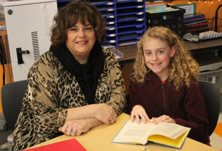 Columbia River Gorge Elementary School fifth-grade student Ella Bingham (right) reads a book with principal Tracey MacLachlan on Feb. 6.