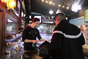 New Vansterdam budtender Connor Baughman (left) helps a customer at the Vancouver cannabis retail shop on Tuesday, Feb. 25. Rachel and James Bean, the owners of New Vansterdam and two other Washington state cannabis retail stores, hope efforts to overturn a ban on cannabis retailers in Camas will be successful. (Kelly Moyer/Post-Record)