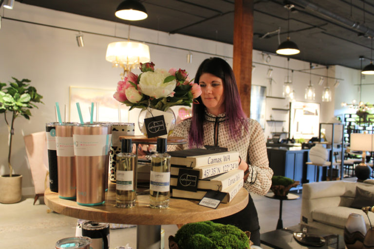 Juxtaposition design consultant Megan Pickett arranges a display inside the new downtown Camas furniture and home decor shop on Friday, Feb.
