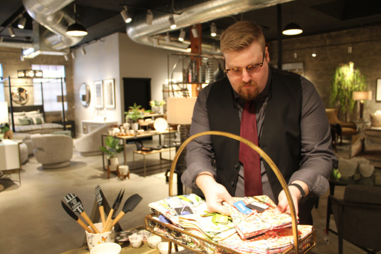 David Nutter, a design consultant at the newly opened Juxtaposition shop in downtown Camas, sorts linens inside the &quot;art inspired Northwest living&quot; furniture and home decor shop on Friday, Feb.