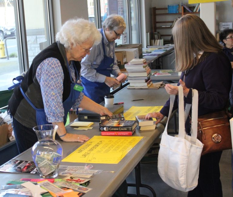 Merrie Thompson of Friends of Washougal Community Library (left) assists a customer during a book sale in downtown Washougal on Friday, Feb.  28. The book sale raised funds for the construction of a new library in Washougal.