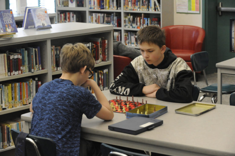 Canyon Creek Middle School students Cole Lott (left) and Taylor Rooks play chess during 100 Percent Day on March 6.