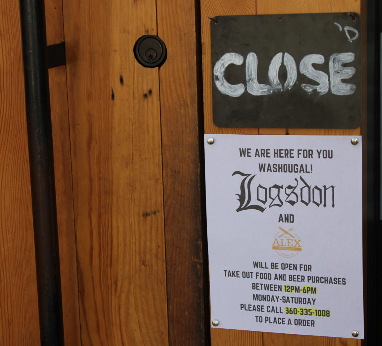 A sign posted on the front door of Alex Smokehouse/Logsdon Farmhouse Ales in Washougal on Monday, March 16, informs customers about the business’ plans to offer take-out service.