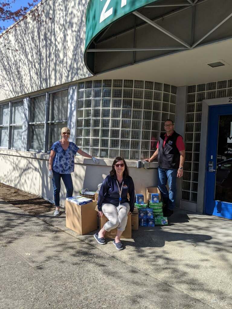 (Contributed photo by Rene Carroll, courtesy of Washougal School District) Career and technical education directors Margaret Rice (left), Tiffany Gould (center) and Mark Wreath (right) stand next to boxes of personal protective equipment they donated to Legacy Salmon Creek Medical Center.