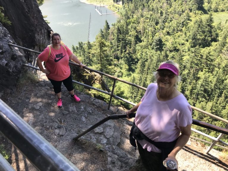 (Post-Record file photo)
Washougal resident Diana Hooper (right) hikes the Beacon Rock trail with her friend, Teresa Casad (left), in June 2019. Hooper has hiked the popular Columbia River Gorge trail more than 50 times. Beacon Rock and other Washington state parks are reopening May 5 for day-use under Gov. Jay Inslee's revised "stay at home" order meant to slow the spread of COVID-19.