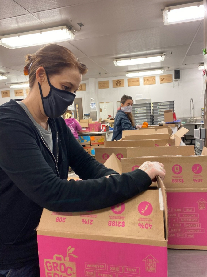 Congressional candidate Carolyn Long wears a mask during a volunteer shift at a local food bank.