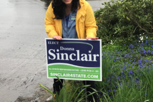 Donna Sinclair, a Democratic candidate running for state legislature in the 18th District, installs a campaign sign in Washougal. Sinclair has had to readjust her campaign strategies during the COVID-19 shutdowns. (Contributed photo courtesy of Donna Sinclair)