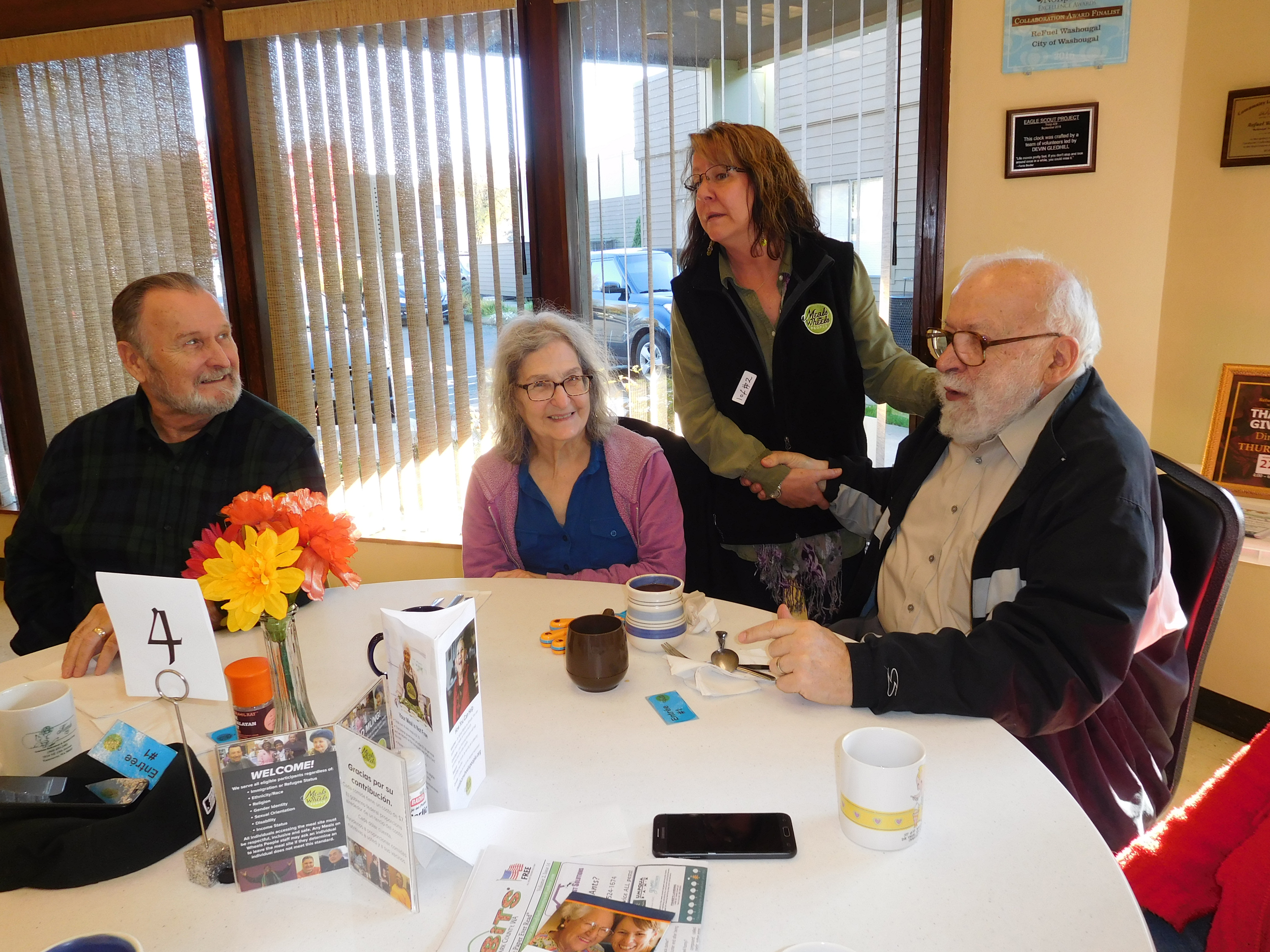 Janice Butzke (second from right), then-manager of the Meals on Wheels People Camas-Washougal site, talks to seniors during a November 2018 lunch at the Washougal Community Center. The Meals on Wheels People has shuttered onsite meal sites during the COVID-19 crisis.Requests for the agency’s food-delivery services have increased in Clark County, especially in Camas-Washougal. (Post-Record file photo)