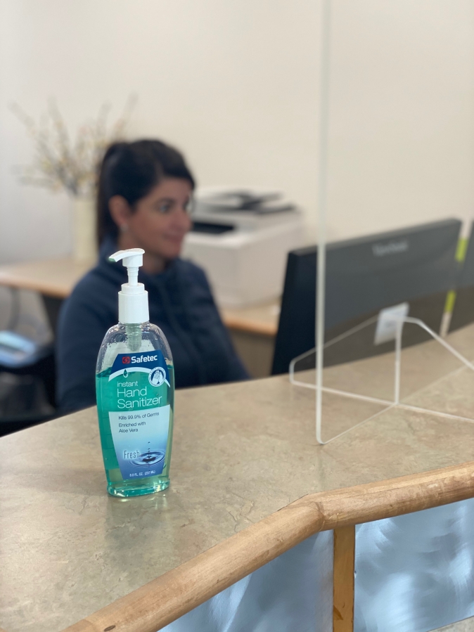 Washougal Family Dental receptionist Jennifer Shega works at her desk, with a bottle of hand sanitizer close by, on Tuesday, June 9.
