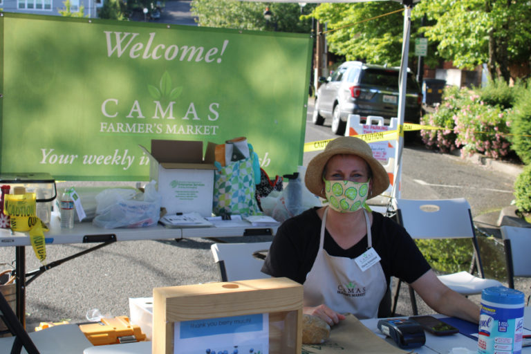 Downtown Camas Association Director Carrie Schulstad sits at the welcoming booth of the Camas Farmer's Market on June 10. The market, which runs from 3 to 7 p.m.