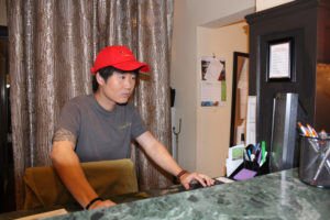 The manager of the Camas Hotel, Won Dongandres Lee Kim, also known as "Brendan Lee," checks a computer in the historic hotel's lobby in August 2019. Kim is facing first-degree arson charges this week after allegedly setting fire to an unoccupied hotel room in a bid to collect insurance money. (Post-Record file photos)