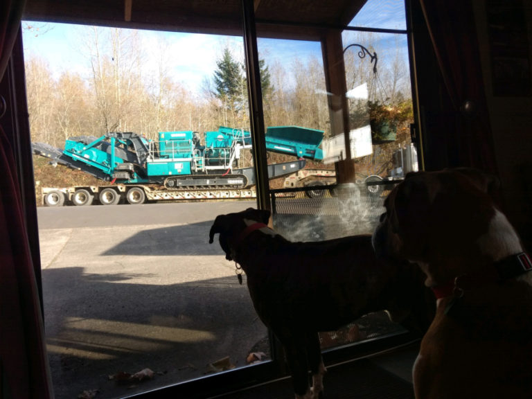 A rock-crushing machine drives past Rachel Grice's home in Washougal, en route to the Washougal sand and gravel pit.