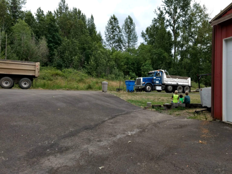 The Grice children watch as trucks pass by their house en route to the Washougal sand and gravel pit off Southeast 356th Avenue in Washougal.